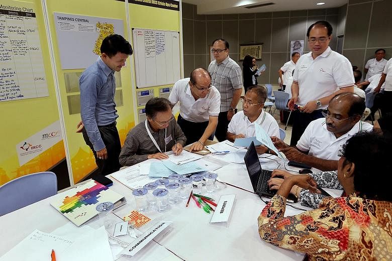 Mr Baey (left) observing the discussion between religious and community leaders during the Inject-Based Exercise at Living Hope Methodist Church yesterday. Mr Steven Lim (third from left), chairman of Tampines Central IRCC, was also present.