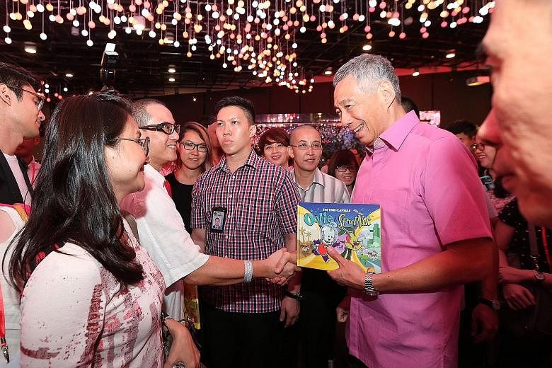 PM Lee meeting guests at last night's appreciation dinner for those who played a part in last year's SG50 events. He also officiated a ceremony for a time capsule that will contain items such as identity cards and school uniforms, and which will be o