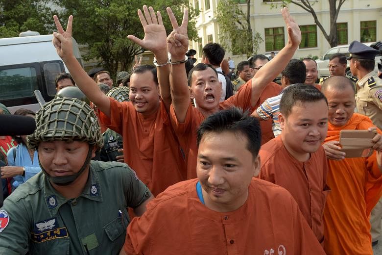 Jailed Cambodian opposition members and activists being escorted by police officials outside the appeal court in Phnom Penh on Thursday.