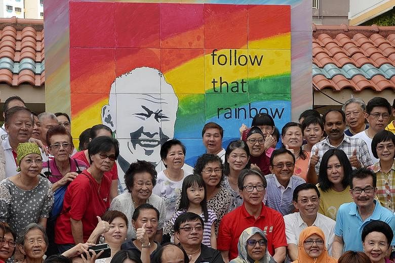 Above: Manpower Minister Lim Swee Say (centre, in red), his fellow East Coast GRC MP Lee Yi Shyan (in white shirt) and grassroots leader Mr Lim Joo Kwan (behind Mr Lee) with Bedok residents and grassroots volunteers in front of a collage of the late 