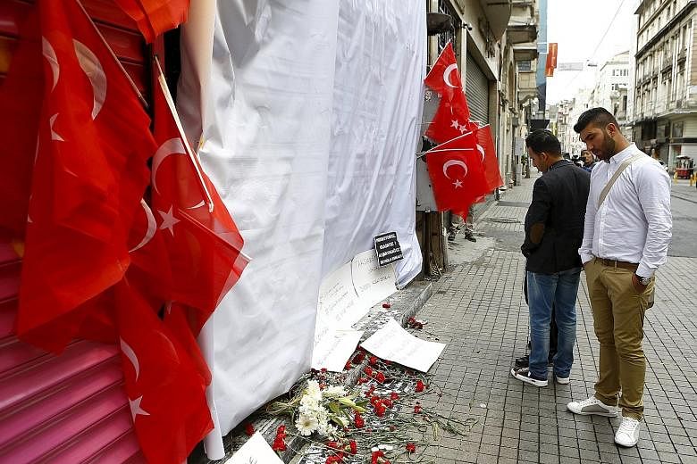 Tributes for victims at the site of the blast in Istiklal street, a major tourist area in central Istanbul, yesterday. Turkish Interior Minister Efkan Ala identified the bomber as Mehmet Ozturk. DNA testing matched samples from Ozturk's father, who l