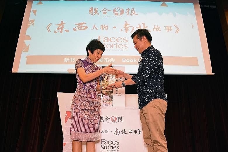 Mr Goh presenting a copy of Faces & Stories of Crossroads to Ms Fu at the launch. The minister said the series offers glimpses of how immigrants have "...successfully integrated in Singapore".