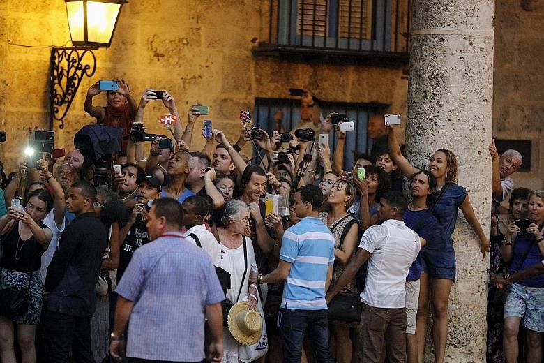 Tourists and local residents taking pictures during the visit of Mr Obama to Old Havana on Sunday. US President Barack Obama and Cuban President Raul Castro in their first meeting on the second day of the American leader's visit to Cuba. Mr Obama is 