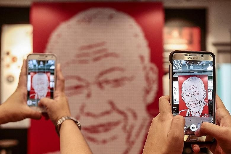 Visitors snapping photos of a mural depicting the late Mr Lee, made out of nearly 5,000 Singapore flag erasers, at a tribute event on Sunday.