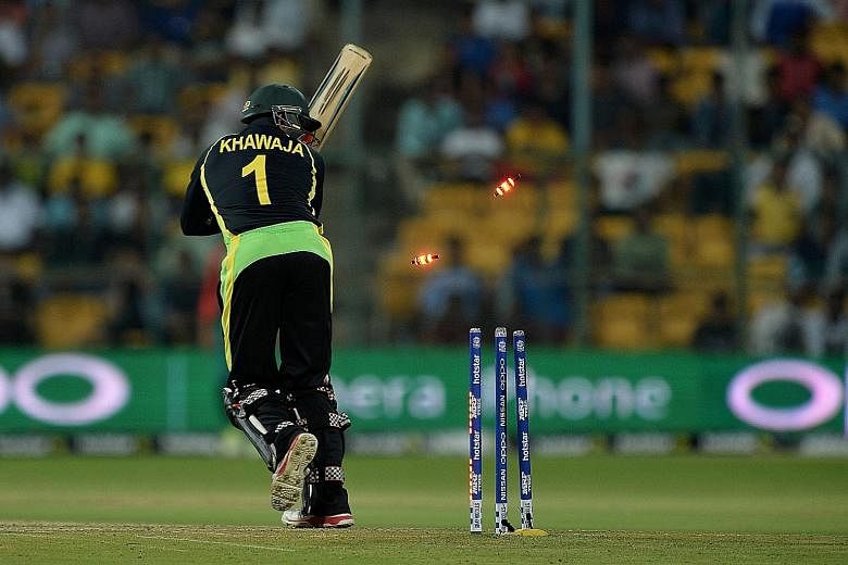 Australia's Usman Khawaja is bowled by Al-Amin Hossain of Bangladesh in the World T20 match in Bangalore on Monday. Australia and hosts India were both beaten earlier by New Zealand, making their quest for a semi-finals spot a lot harder.