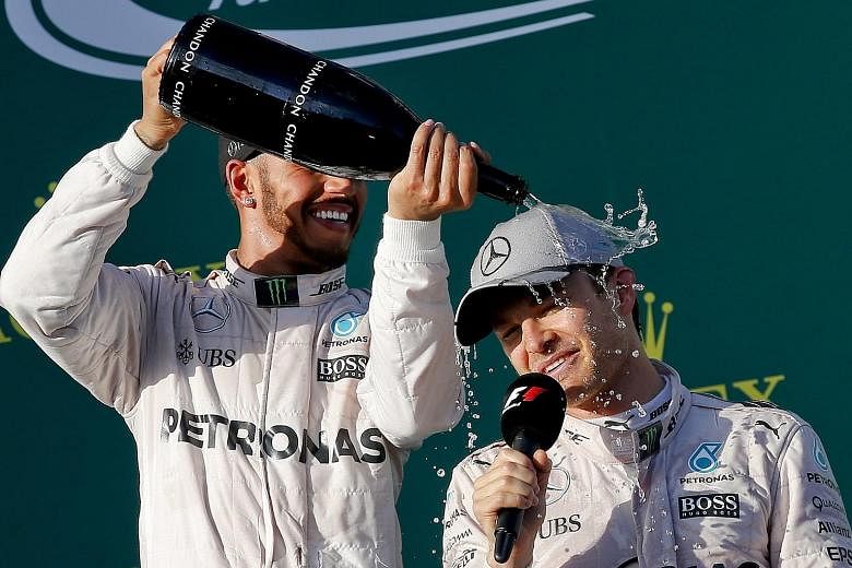 World champion Lewis Hamilton (left) sprays champagne on his Mercedes team-mate Nico Rosberg after the Australian Grand Prix on Sunday. The Briton faces a double challenge, from Rosberg and the two Ferrari drivers, Sebastian Vettel and Kimi Raikkonen