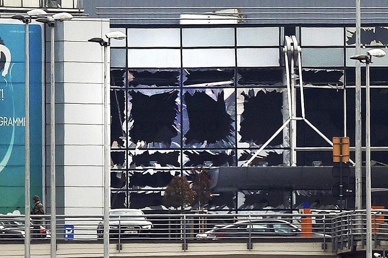 The damaged facade of Brussels Airport, which was rocked by two blasts yesterday. An airport worker who helped to carry out some of the victims' bodies said their legs were shattered.