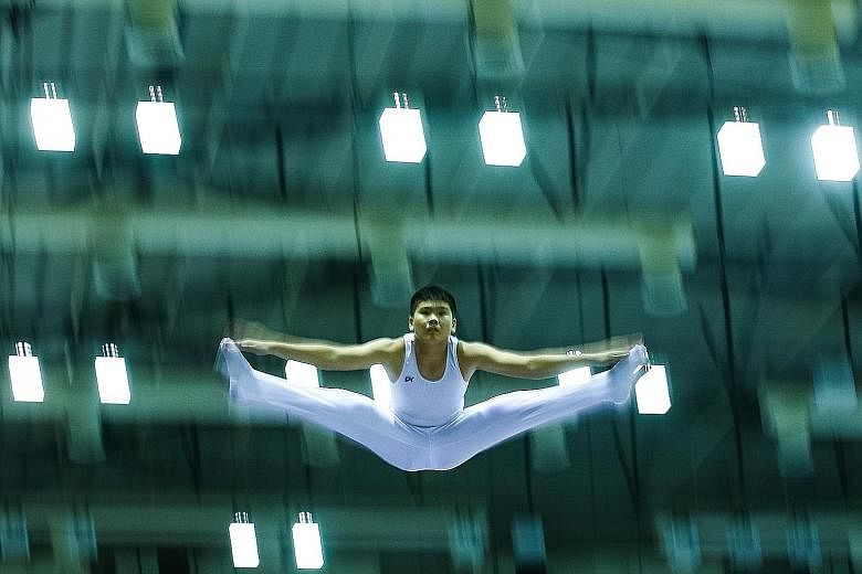 Choong Yih Herng (right) of Hwa Chong Institution (HCI) performs his routine during the B Division competition at the Schools National Gymnastics (Trampoline) Championships at Bishan Sports Hall yesterday. HCI swept the boys' titles in the A, B and C