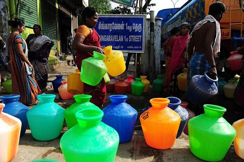 Indian residents carrying plastic pots to collect drinking water from a government tanker at their residential colony in Chennai on Tuesday. International World Water Day is marked annually to focus global attention on the importance of water and pus
