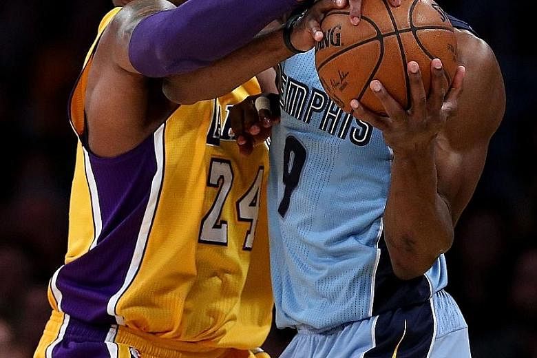 The Lakers' Kobe Bryant (No. 24) tussling for the ball with the Grizzlies' Tony Allen during their match at Staples Centre. The home side won 107-100 to end a four-game losing streak.