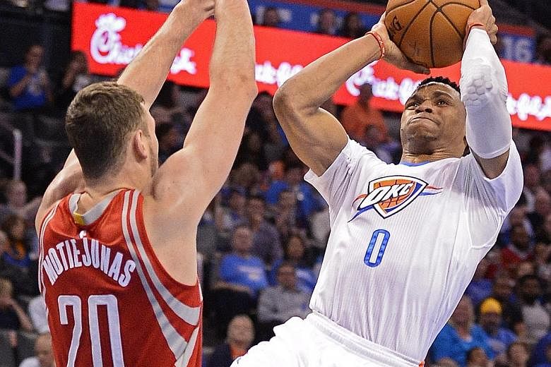 Donatas Motiejunas (far left) of the Houston Rockets trying to block a shot by Oklahoma's Russell Westbrook during the hard-fought 111-107 win by the Thunder.