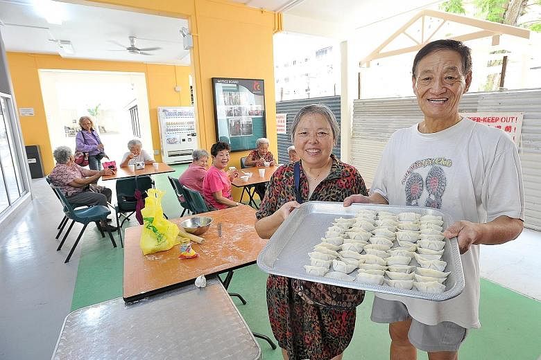 Madam Chen Yuemei (left), 68, and her husband, Mr Wang Ye, 69, both retirees, teach elderly residents how to make dumplings at Palmwalk Cafe Corner, which is located at the void deck of Block 839, Tampines Street 83. The newly opened community cafe i