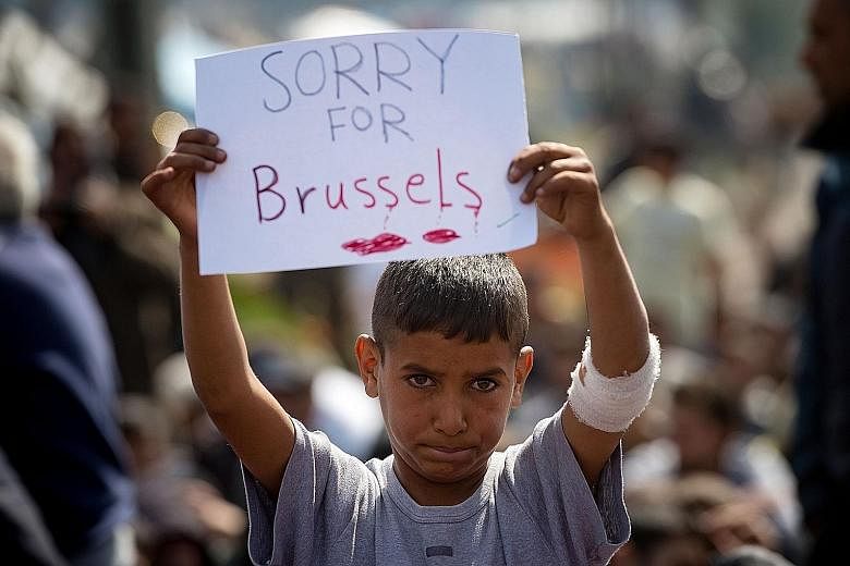 A boy expressing sympathy for the victims of the terror attacks in Brussels during a protest at a makeshift camp at the Greek-Macedonian border near the village of Idomeni on Tuesday. The attacks prompted new questions about European solidarity and s