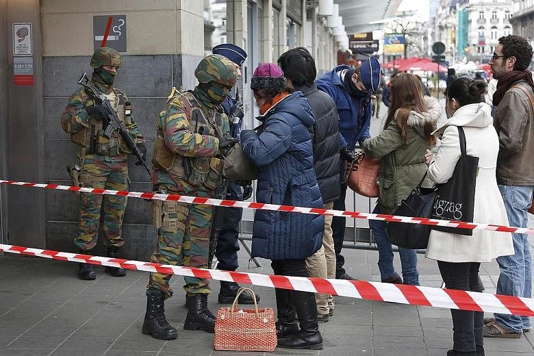 Troops searching people entering a subway station in Brussels yesterday. The Belgian capital was in a lockdown for most of Tuesday.