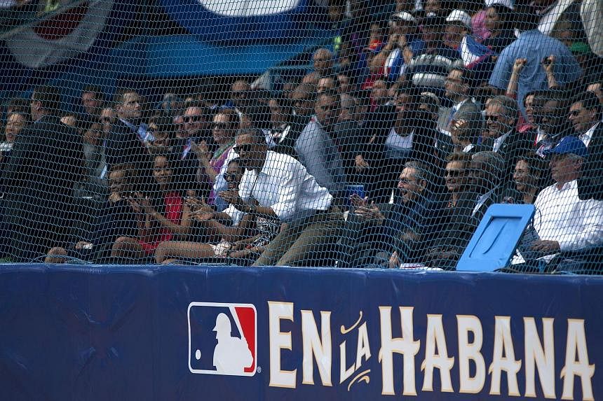 US President Barack Obama (in white shirt) and, at his left, Cuban President Raul Castro at an exhibition game between the Cuban and US baseball teams in Havana on Tuesday. The US leader travelled to Argentina after his historic Cuban visit.