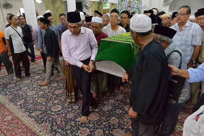 Dr Yaacob carrying the coffin of writer Dr Ariff, alongside family members, yesterday. The minister said Dr Ariff was a pioneer who made tremendous contributions to the community.