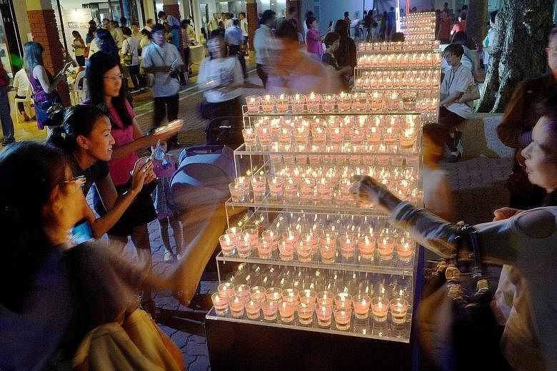 Gel candles, which were handmade by residents and grassroots volunteers, being lit at Tanjong Pagar Community Club last night, to mark the first anniversary of Mr Lee's death. Some did what Mr Lee would have done: they went on a brisk walk across tow
