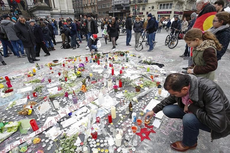 The Bakraoui brothers Ibrahim (top) and Khalid are also suspected of being connected to the Nov 13 terror attacks in Paris that killed 130 people. The many gifts and tributes at the Place de la Bourse in Brussels yesterday in memory of the 31 killed 