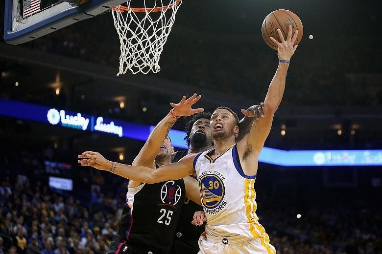 Stephen Curry (No. 30) of the Golden State Warriors going up for a shot against Austin Rivers (No. 25) and DeAndre Jordan of the Los Angeles Clippers on Wednesday. The Warriors' 114-98 win sealed a 4-0 season-series sweep against the Clippers.