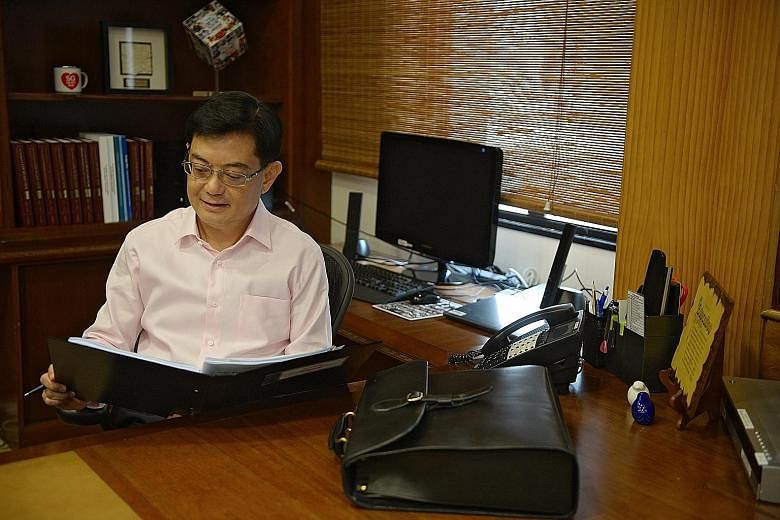 Finance Minister Heng Swee Keat, in his office yesterday, prior to delivering his maiden Budget. Analysts said the Budget was a prudent one, with Mr Heng balancing short-term concerns and long-term challenges. The Government pledged to support worker