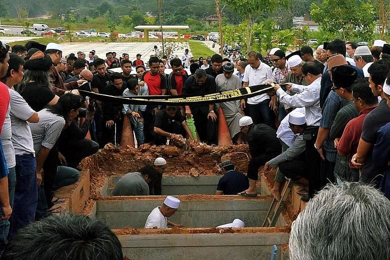 The funerals of SMRT trainees Muhammad Asyraf and Nasrulhudin at the Muslim cemetery in Lim Chu Kang on Wednesday. The two men were killed on Tuesday when they were hit by an oncoming train.