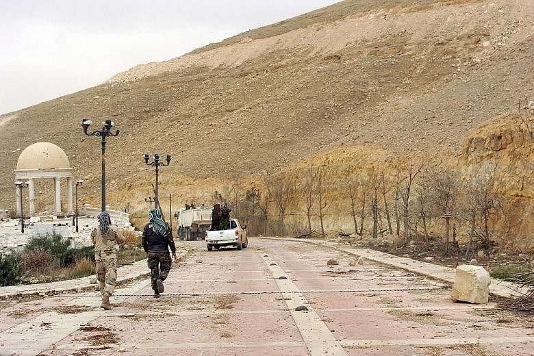 Syrian soldiers walking down a Palmyra street. A Russian officer was killed in combat near the city recently, suggesting the Kremlin has been more deeply engaged in the conflict than it has acknowledged.