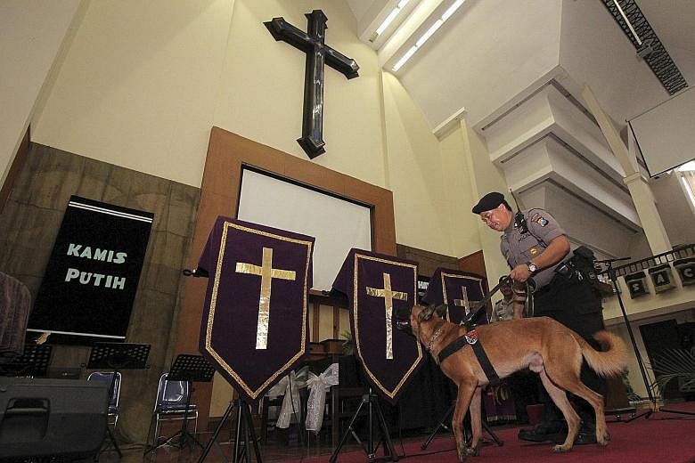 A police officer and his dog searching a church ahead of Easter celebrations in Surabaya, Java. Indonesia has intensified security at churches and other places this Easter weekend.