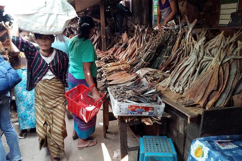 Mr Saw Hdaik Oo (above) is back home in Dawei, Myanmar, after 15 years in Thailand. He still works for his Thai boss, who is expanding the business to Dawei. A market (left) in Dawei.