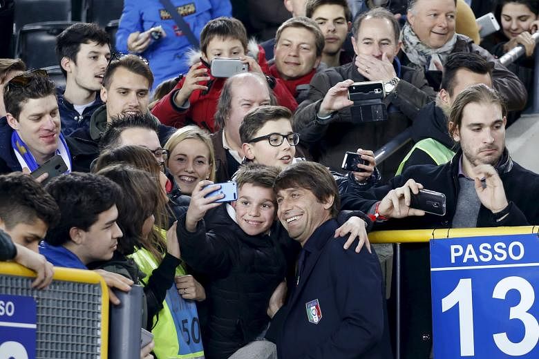 Meanwhile, Italy coach (above ) Antonio Conte (posing with a fan) is slated to take the reins at Chelsea after leading the Italians at Euro 2016, with an officer from the Premier League club spotted in close quarters with the Italian's contingent at the m