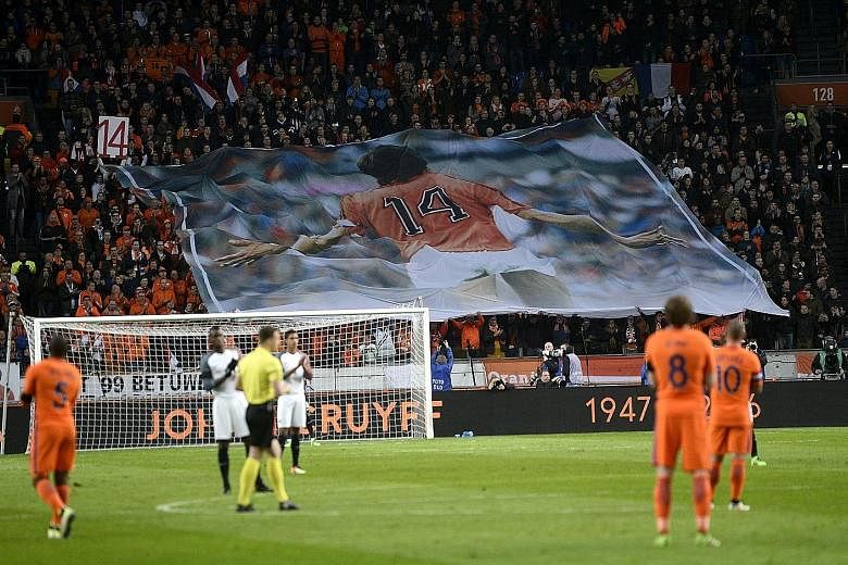 Players for the Netherlands and France teams stopped play during the 14th minute of their friendly match at Amsterdam ArenA on Friday to pay tribute to Johan Cruyff. The Dutch legend died on Thursday after a five-month battle with lung cancer.