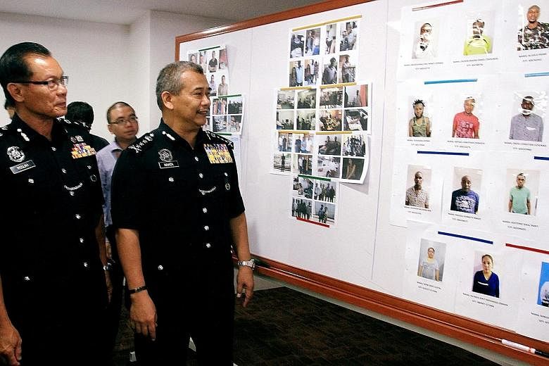A Malaysian police press conference held last year, where photos of African suspects in love scams were displayed. There were 14,627 cases of online scams last year, in which victims lost a total of RM1.09 billion.