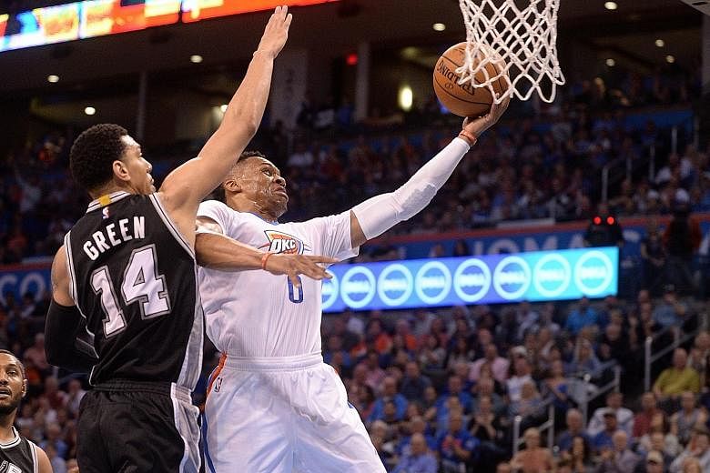 Oklahoma City guard Russell Westbrook driving to the basket in front of San Antonio guard Danny Green during their game at Chesapeake Energy Arena. The Thunder won easily 111-92 against the under-manned Spurs.