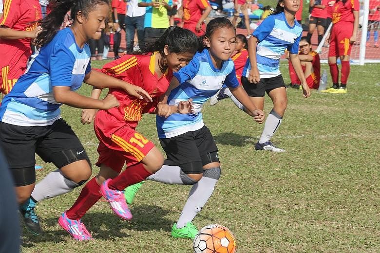 Team TPSS Titanides (in red) playing against Team Bullet Girls in a five-a-side tournament during Women's Football Day last month. About 550 women and girls took part in the event. Women's football here is poised for a revival after years in the dold
