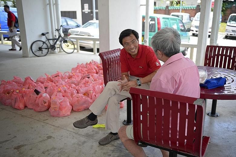 SDP's Dr Chee talking to a resident before he and his team distributed groceries in Block 210A, Bukit Batok Street 21, yesterday.