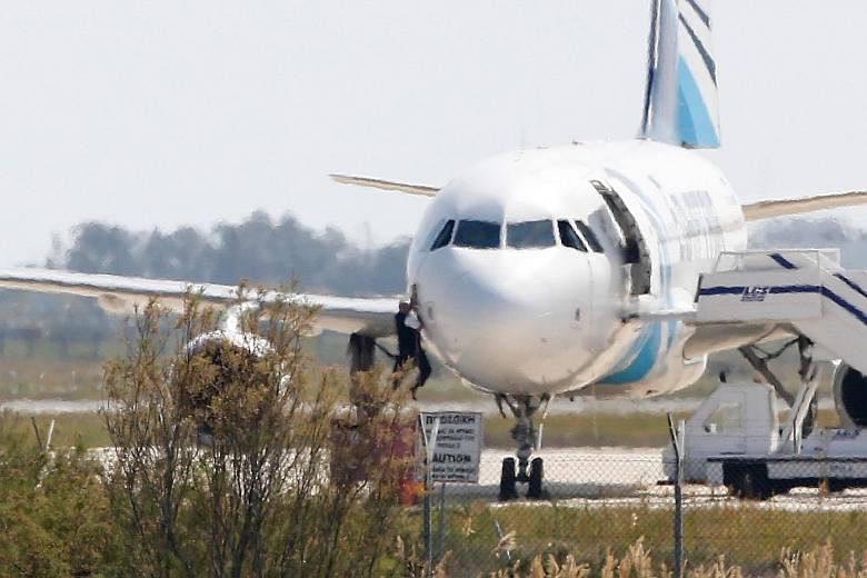 An EgyptAir Airbus A-320 from Alexandria bound for Cairo was hijacked yesterday and flown to Larnaca airport in Cyprus. Once on the tarmac, passengers were progressively released, including this man seen climbing out of a cockpit window. In the end, 