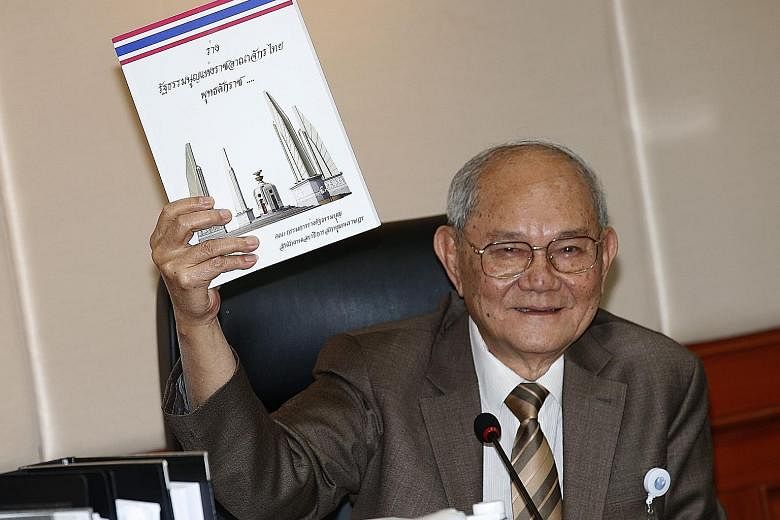 Constitution drafting committee chairman Meechai Ruchupan with a copy of the draft Constitution yesterday.