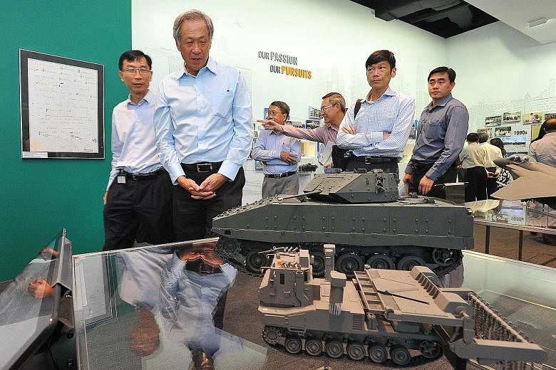 Dr Ng (second from left) viewing models of the Bionix Infantry Fighting Vehicle and Trailblazer Countermine Vehicle at the DSTA Gallery in the DSTA Integrated Complex during the opening ceremony of the new complex yesterday.