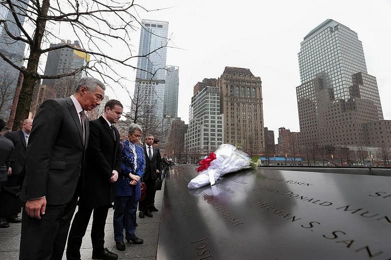 PM Lee and his wife Ho Ching at the National September 11 Memorial & Museum in New York on Monday. The names of the victims of the attack are etched on panels surrounding two pools.