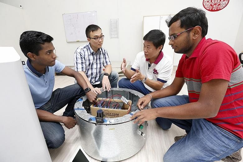 Mr Lee (second from right), Aitech's founder, and (from left) engineers Seenivasan Lalithkumar, Jonathan Chang and Venkatachalam Singaram examining a prototype they had developed.