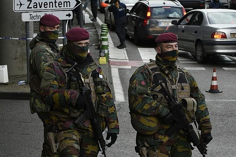 Belgian soldiers and police securing routes to Brussels airport yesterday. The airport's chief executive Arnaud Feist said it could take months for it to be fully operational again.