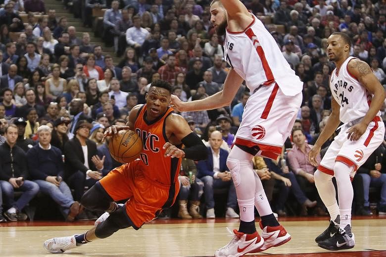 Oklahoma City Thunder guard Russell Westbrook appears to test the limits of gravity as he evades Toronto Raptors centre Jonas Valanciunas (right) during the Thunder's 119-100 victory in Toronto on Monday. 