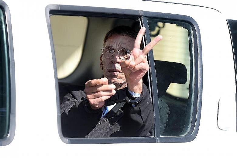 Mustafa flashing a victory sign at reporters as he left the court in a police car yesterday. He had diverted a flight to Cyprus while wearing a fake suicide vest made of mobile phone covers and wires.