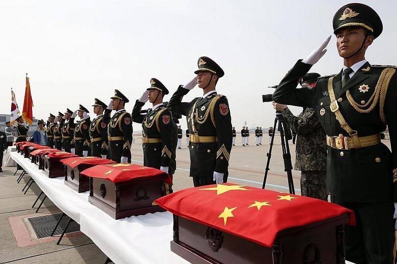 Members of a Chinese honour guard in front of boxes holding the remains of Chinese soldiers killed in the 1950-53 Korean War during a repatriation ceremony yesterday at Incheon Airport in South Korea. The repatriation of the remains of 36 Chinese sol
