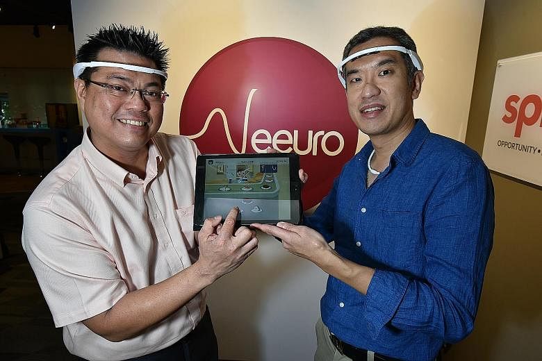 Dr Leong (far left) and Dr Chan wearing the headbands, which measure the brainwaves of users as they play Neeuro Memorie games. On display on the tablet is one of the games, Sushi Recall. It requires players to recreate the sequence in which sushi pl