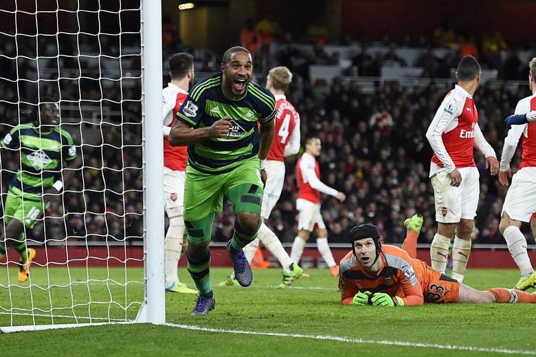 Arsenal's players are stunned as Swansea City's Ashley Williams (left) scores the winner against them in a Premier League clash on March 2. The Gunners took the lead but allowed their bottom-half rivals to bounce back and win 2-1.