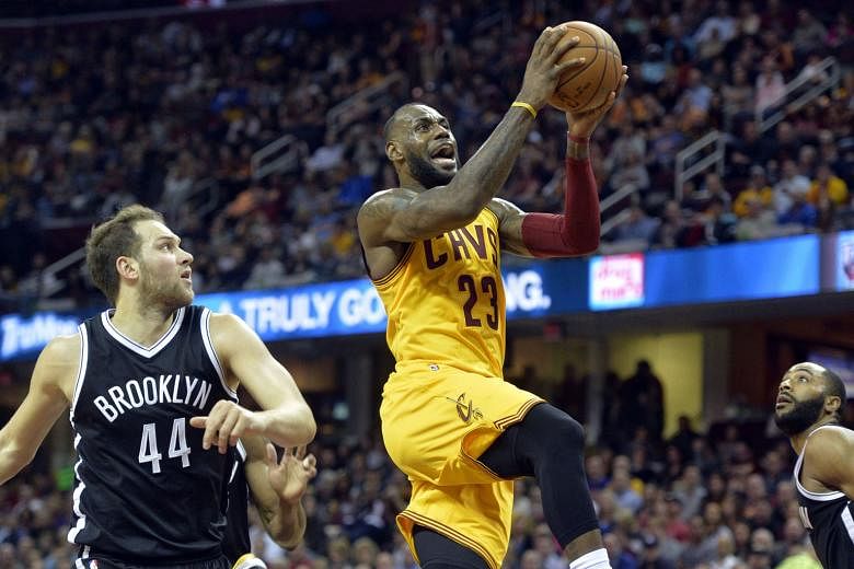 Cavaliers forward LeBron James drives past Nets guard Bojan Bogdanovic en route to two of his 24 points on the night, taking him to 12th on the NBA's all-time scoring list. 