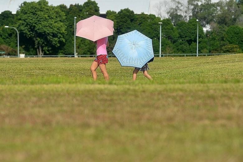 People carrying umbrellas to shield themselves from the blazing sun in Bishan central yesterday. Singapore experienced its hottest day this year when the temperature soared to a blistering 35.6 deg C yesterday. The weatherman has cautioned that tempe