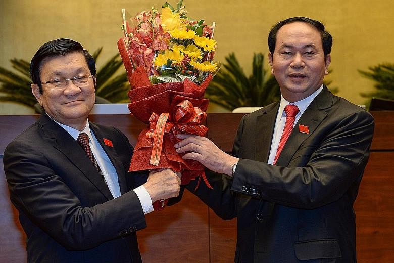 President Tran Dai Quang (right) with his predecessor Mr Truong Tan Sang during a ceremony after being elected Vietnam's new president by parliament in Hanoi yesterday.