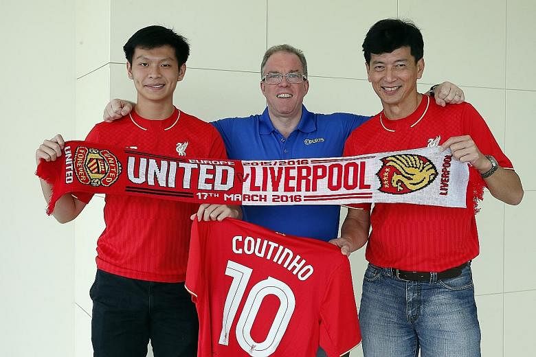 Ashley (left) and Vincent Ong flank Courts CEO Terry O' Connor. The father and son display the Manchester United-Liverpool Europa League match scarf and the signed jersey they received from their favourite player Philippe Coutinho.