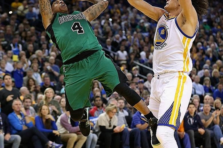 Isaiah Thomas of the Boston Celtics (left) finds plenty of air time as he goes up for a shot against Anderson Varejao of the Golden State Warriors in the 109-106 victory at Oracle Arena on Friday.